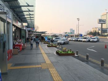 Cars on road in city against clear sky