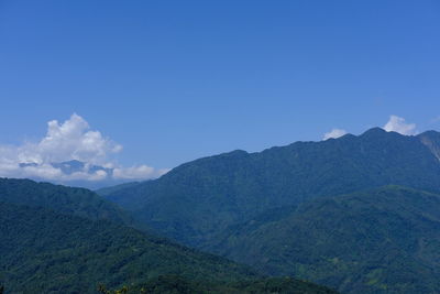 Scenic view of mountains against blue sky