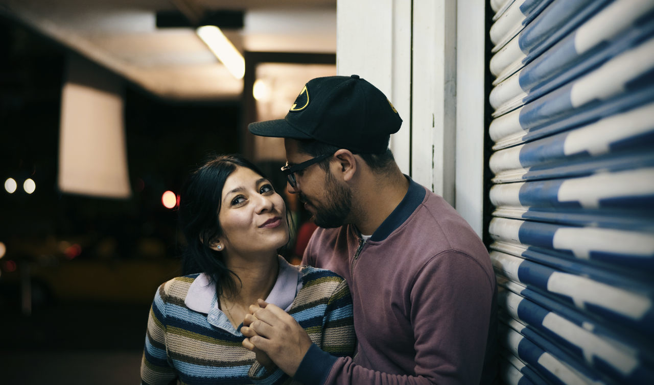 two people, togetherness, young adult, couple - relationship, men, young men, adult, love, real people, women, indoors, young women, emotion, heterosexual couple, lifestyles, hat, leisure activity, casual clothing, smiling, people, positive emotion