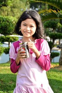 Portrait of happy girl holding ice cream in park