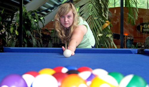 Portrait of woman playing with ball on table