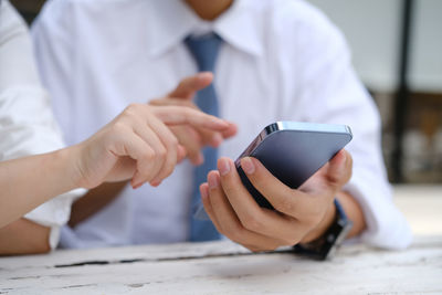 Midsection of man using mobile phone