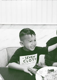 Portrait of smiling boy sitting on sofa