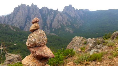 Close-up of statue on rock against sky