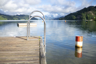 Scenic view over millstätter lake from a beach with jetty to mountains