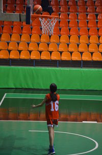 Rear view of man playing soccer on field