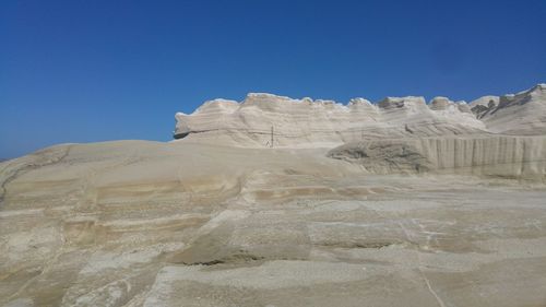 Scenic view of desert against clear blue sky