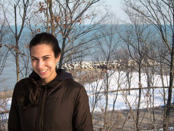 Portrait of smiling young woman standing in winter