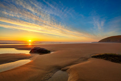 Scenic view of beach against sky during sunset