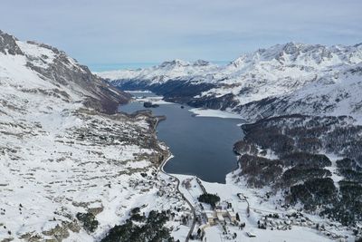 Scenic view of snow covered mountains by lake against sky