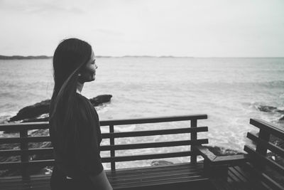 Woman looking at sea against sky