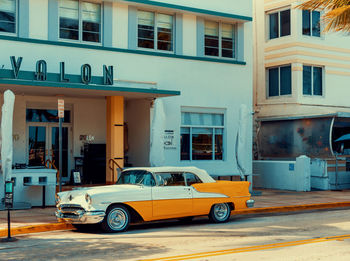 Car on street against buildings in city