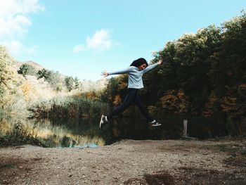 Full length of man jumping in mid-air against sky