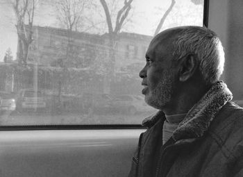 Portrait of man looking through window