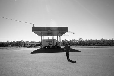 Man with arms raised against clear sky