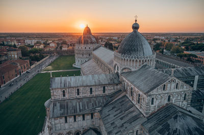 Aerial view of buildings in city at sunset