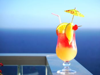 Close-up of drink in glass against blue sky