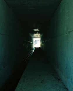 Empty walkway in illuminated tunnel