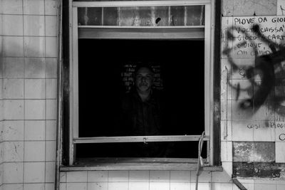 Portrait of woman standing by window