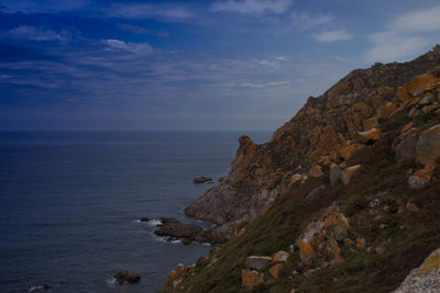 Rock formations by sea against sky