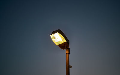 Low angle view of illuminated street light against clear sky