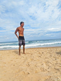 Full length of shirtless man on beach