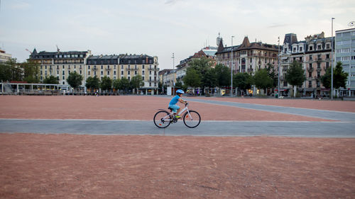 Rear view of man riding bicycle on street
