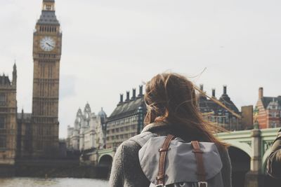 Rear view of woman looking big ben while standing by thames river