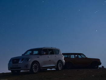 Vintage car on land against clear blue sky at night