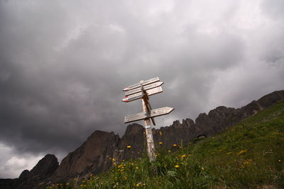 Low angle view of cross on mountain against sky