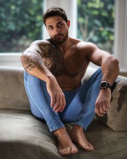 Young man sitting on sofa at home