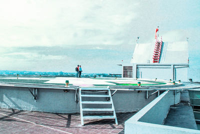 People standing on helipad against sky