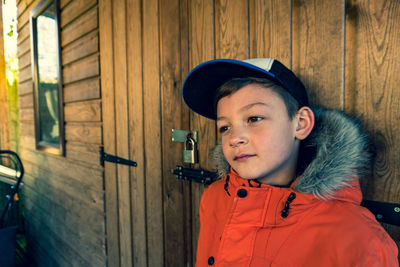 Portrait of boy standing against wall