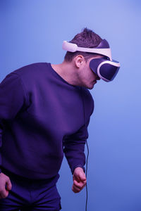 Midsection of man standing against blue background