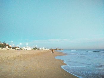 Scenic view of beach against clear blue sky