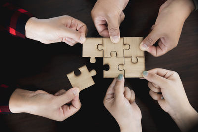 Cropped hands of person holding jigsaw puzzle