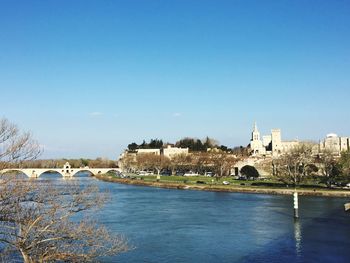 Arch bridge over river against buildings in city