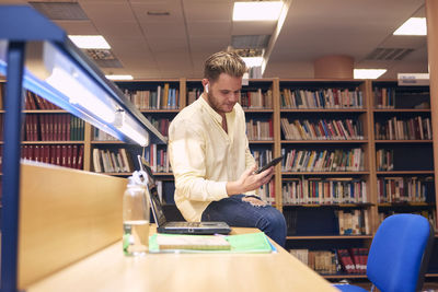 Portrait of a boy making a video call in a library