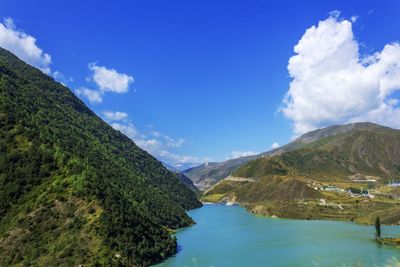 Scenic view of river amidst mountains against sky