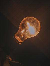 Low angle view of illuminated lamp against dark sky