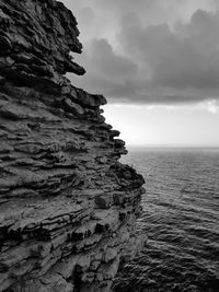 Rock formations by sea against sky