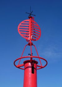 Low angle view of red light against blue sky