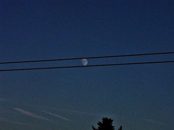 Low angle view of power lines against blue sky