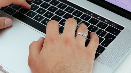 Close-up of hands using laptop