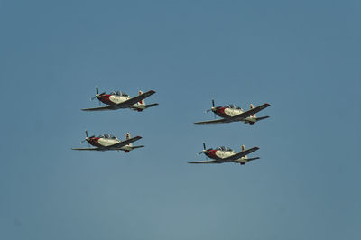 Low angle view of airshow against clear blue sky