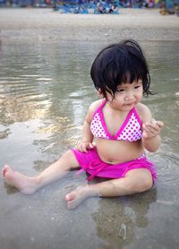 High angle view of cute girl sitting at beach