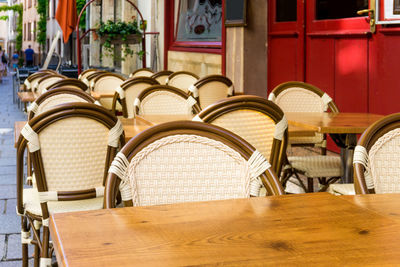 Empty chairs by table at sidewalk cafe