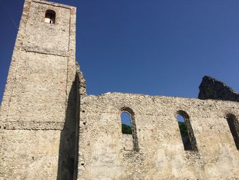 Low angle view of old building against clear blue sky