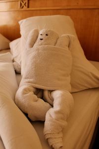 Towels in human shape on bed