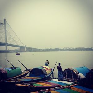 View of suspension bridge over river against sky